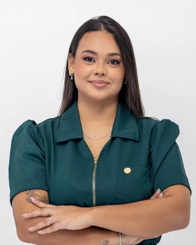 Dra. Isa Lopes, de uniforme verde, com os braços cruzados